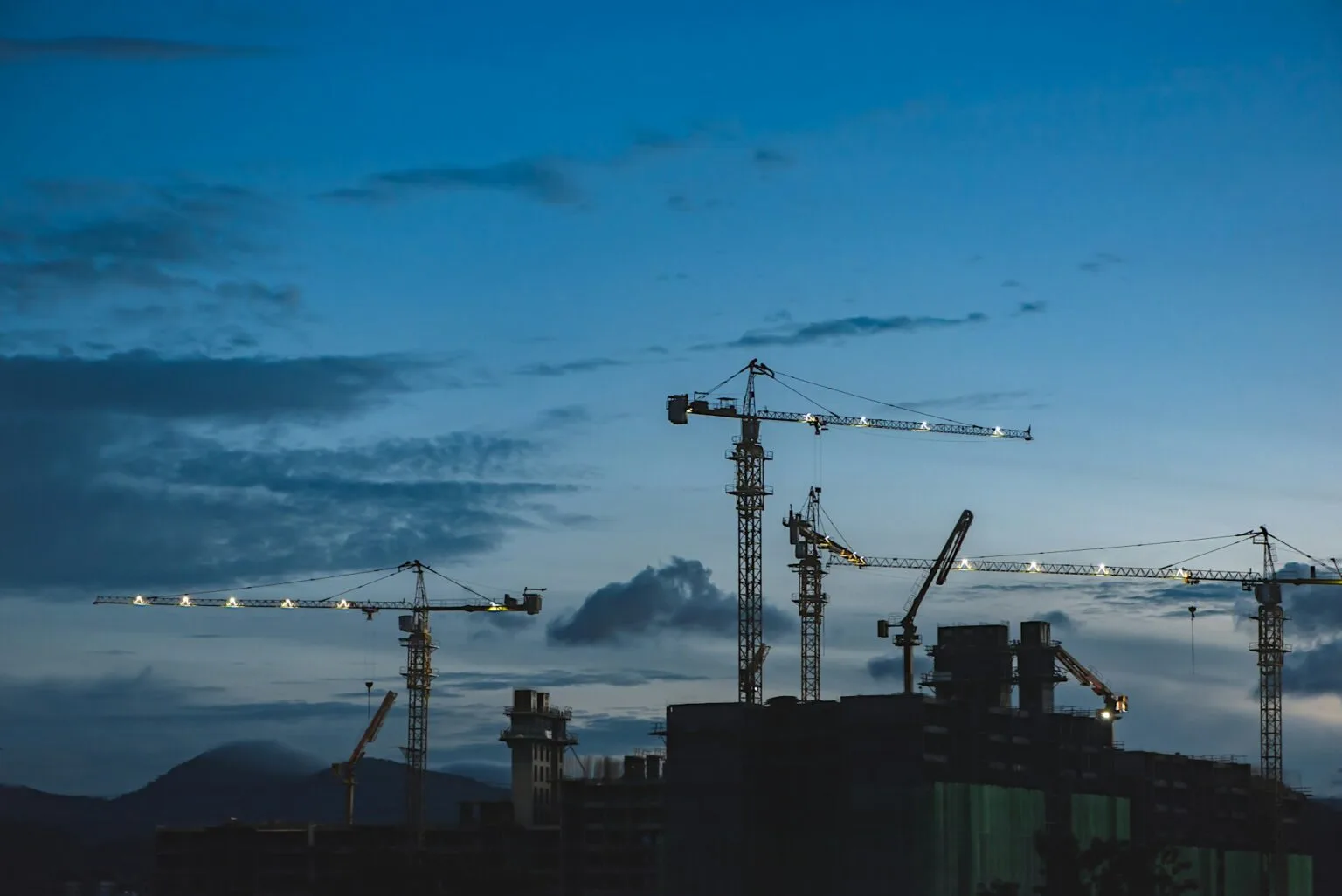 Tower cranes over a building site at dusk